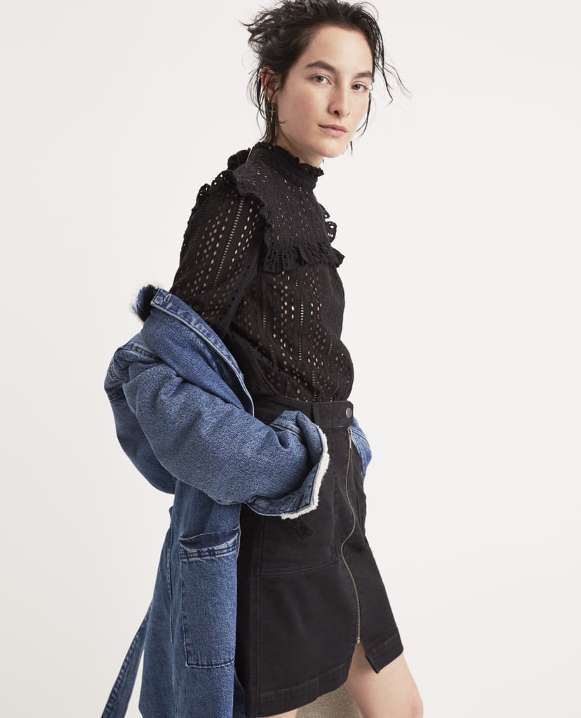 A denim coat dresses down the frilly and feminine top.