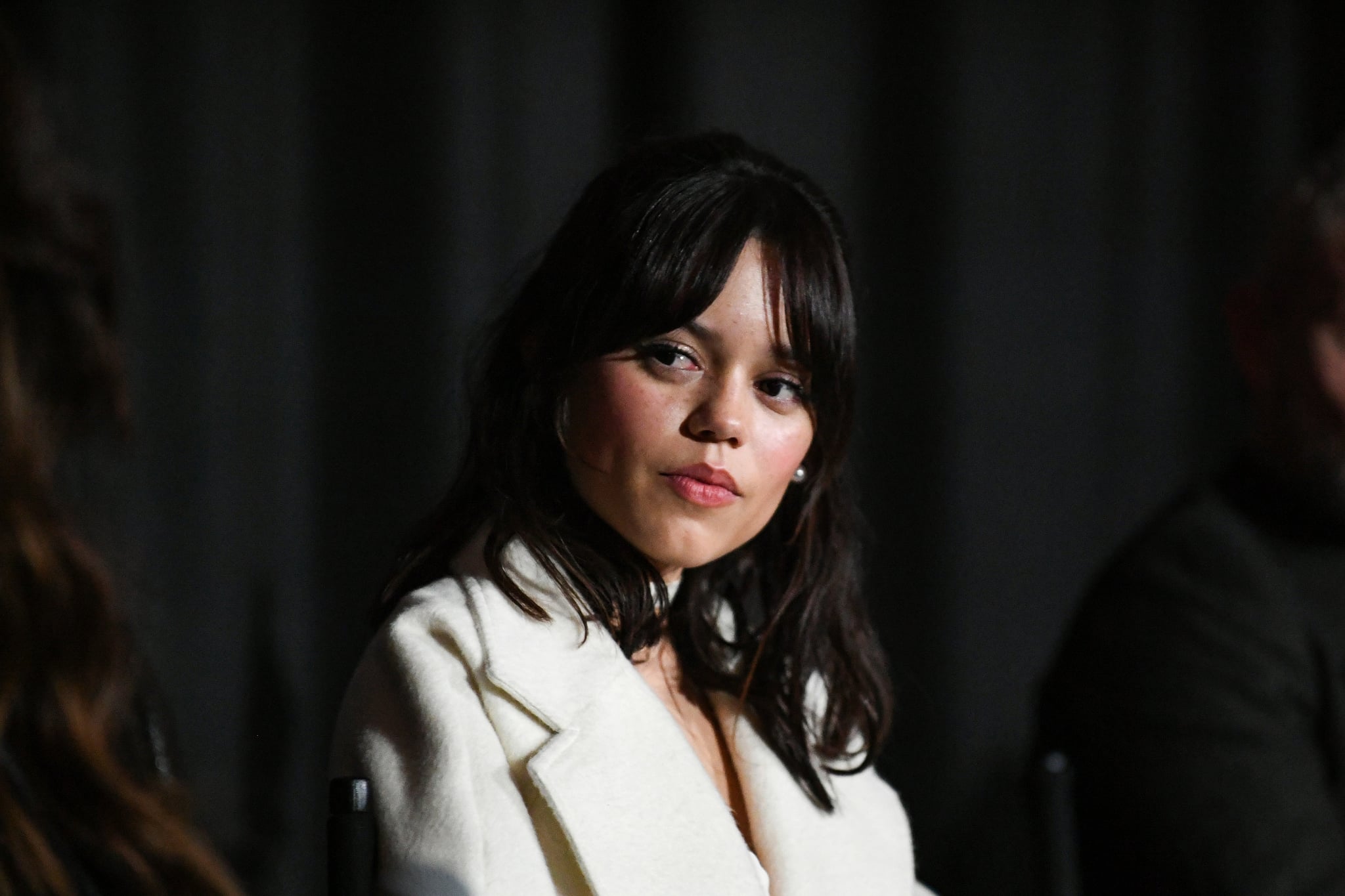 A close-up of Jenna Ortega's face as she speaks onstage.