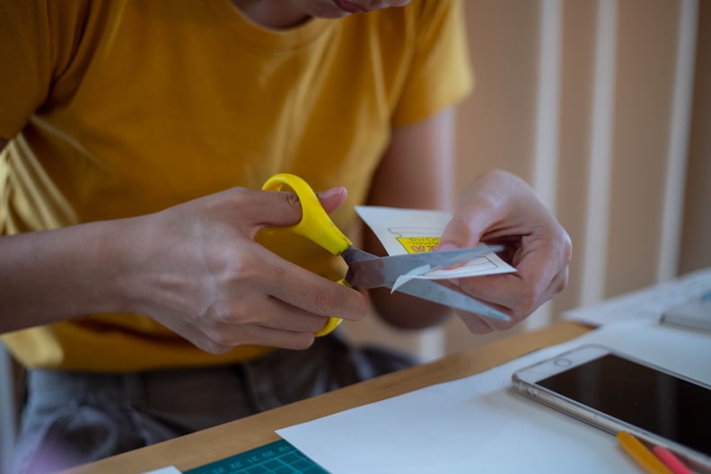 woman's hand cutting paper