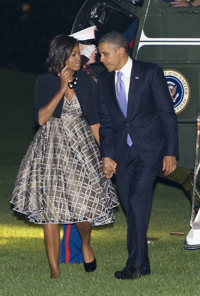 Arriving back at the White House, Michelle was spotted in an olive, tartan-inspired circle dress with a black cardigan.
Arriving back at the White House, Michelle was spotted in an olive, tartan-inspired circle dress with a black cardigan.