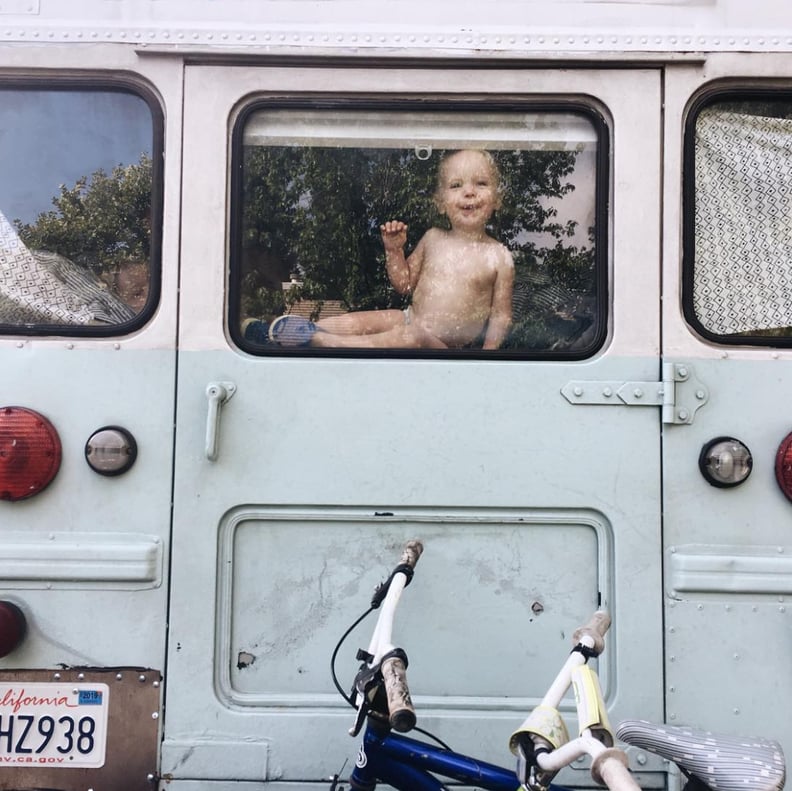 The back of the bus, and a toddler peeping through the window!