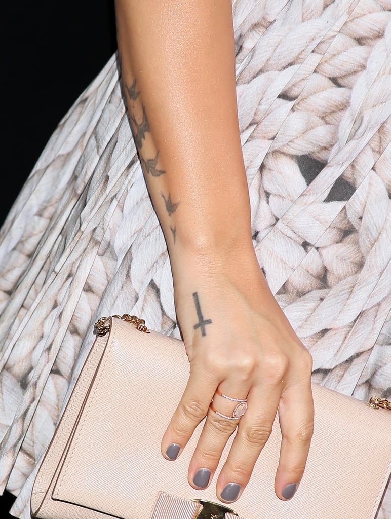 The cross on Demi's hand is there to be prominently seen when she holds a microphone, and it represents her Christian faith.