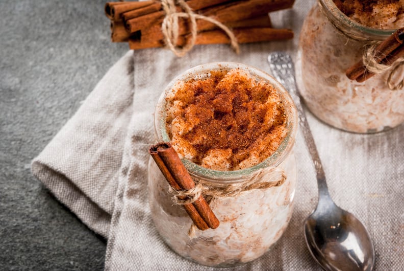 Spanish, South American, Mexican dessert. Sweet porridge, rice pudding. Arroz con leche. In portioned jars, decorated with cinnamon and sugar. On a dark stone table. Copy space