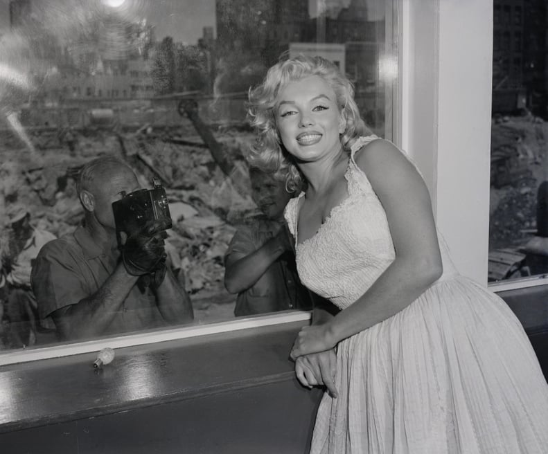 (Original Caption) 7/2/1957-New York, NY: After she had kept 1,500 fans, 20 cops and 40 photographers waiting for two hours and 20 minutes today, actress Marilyn Monroe poses at a picture window of the 
