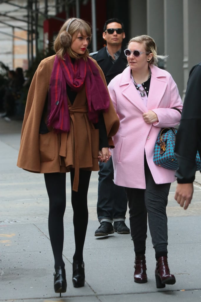 We don't know what's cuter: Taylor holding hands with Lena Dunham or the singer's stylish brown cape.