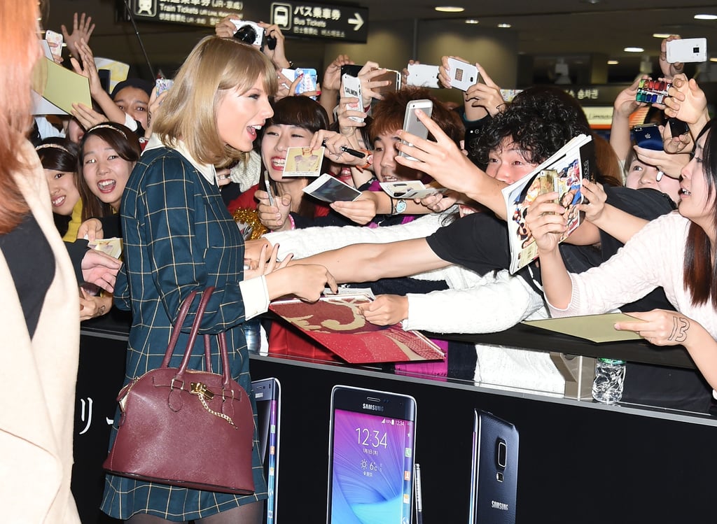 Taylor Swift greeted hundreds of fans at the Tokyo airport with a smile on Tuesday.