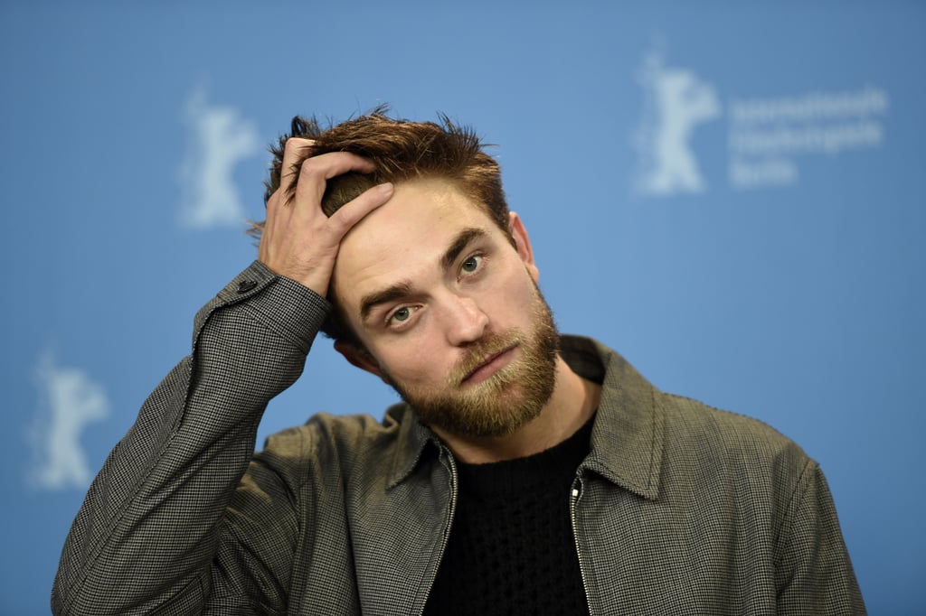 Rob was serious while stroking his hair during the Berlin Film Festival in February 2015.