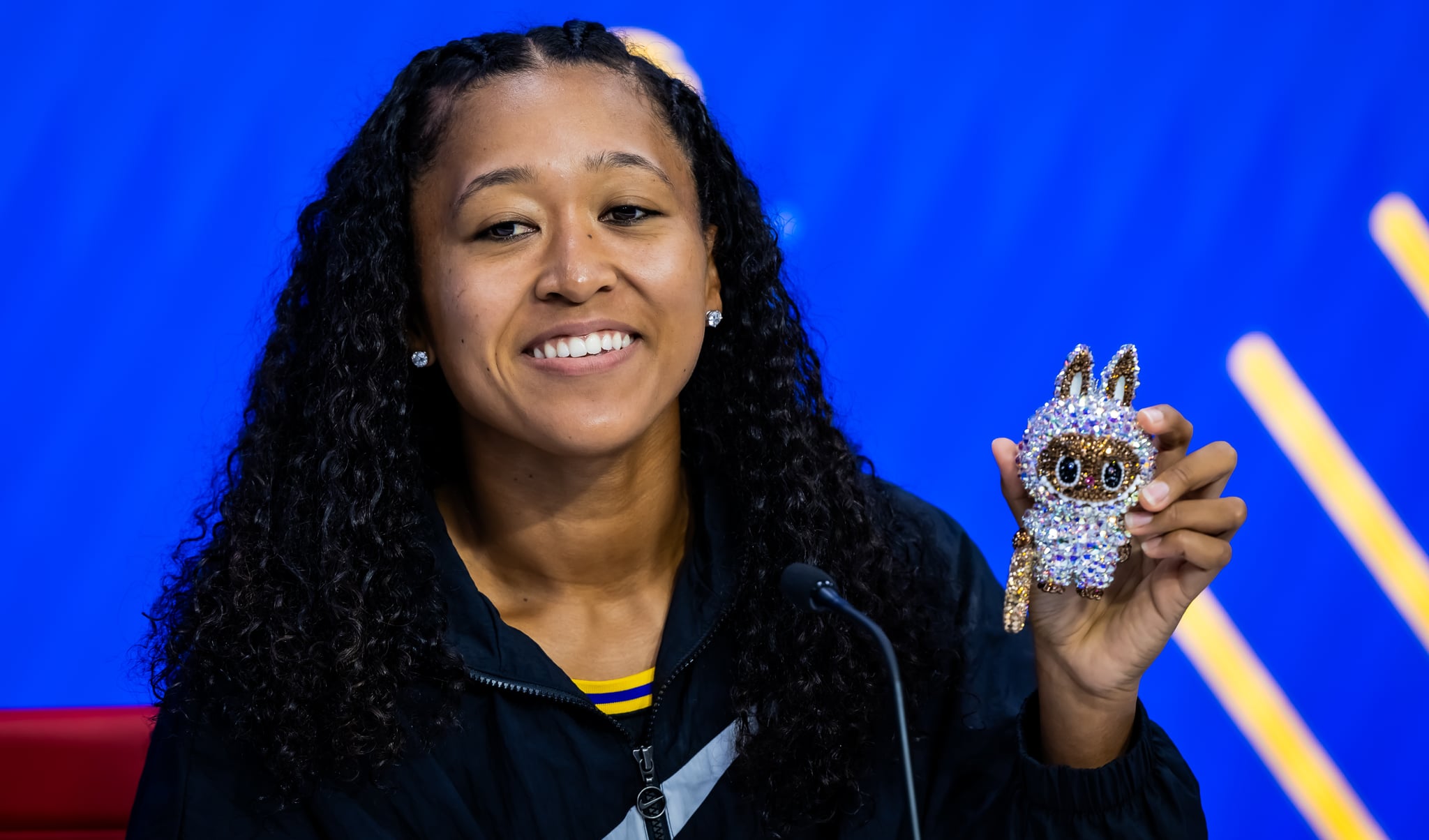 Naomi Osaka of Japan shows off her Labubu Althea Glitterson while talking to the media after defeating Coco Gauff.
