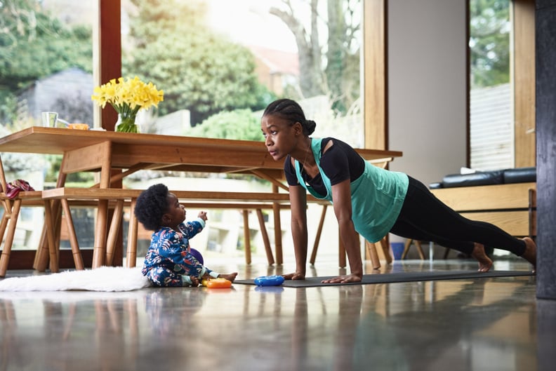 Baby boy (6-11 months) assisting mother performing yoga in livingroom