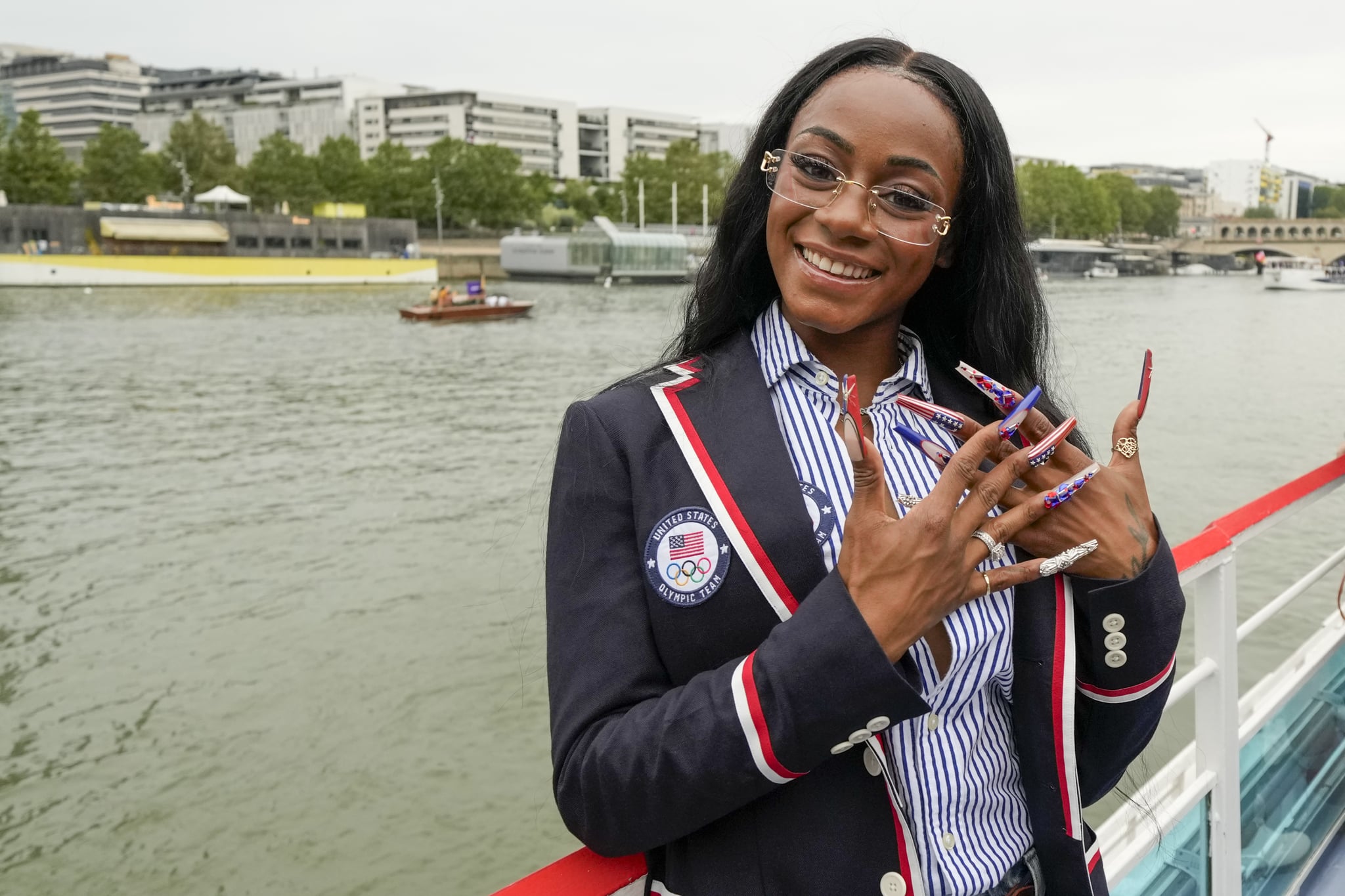 PARIS, FRANCE - JULY 26: Sha'Carri Richardson poses for a photo while riding with teammates on a boat with teammates along the Seine River during the Opening Ceremony of the Olympic Games Paris 2024 on July 26, 2024 in Paris, France. (Photo by Ashley Landis - Pool/Getty Images)