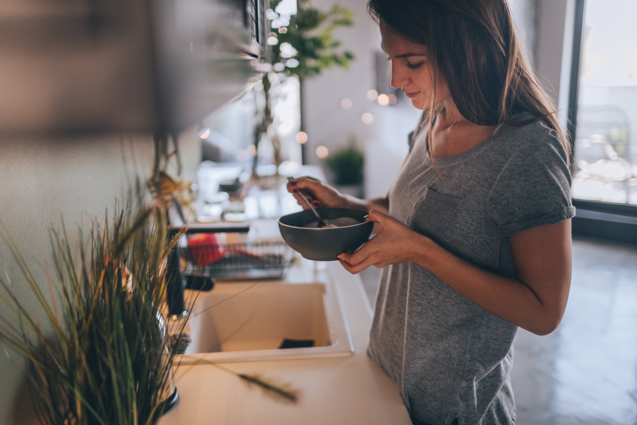 Young woman having healthy breakfast in the morning in her apartment