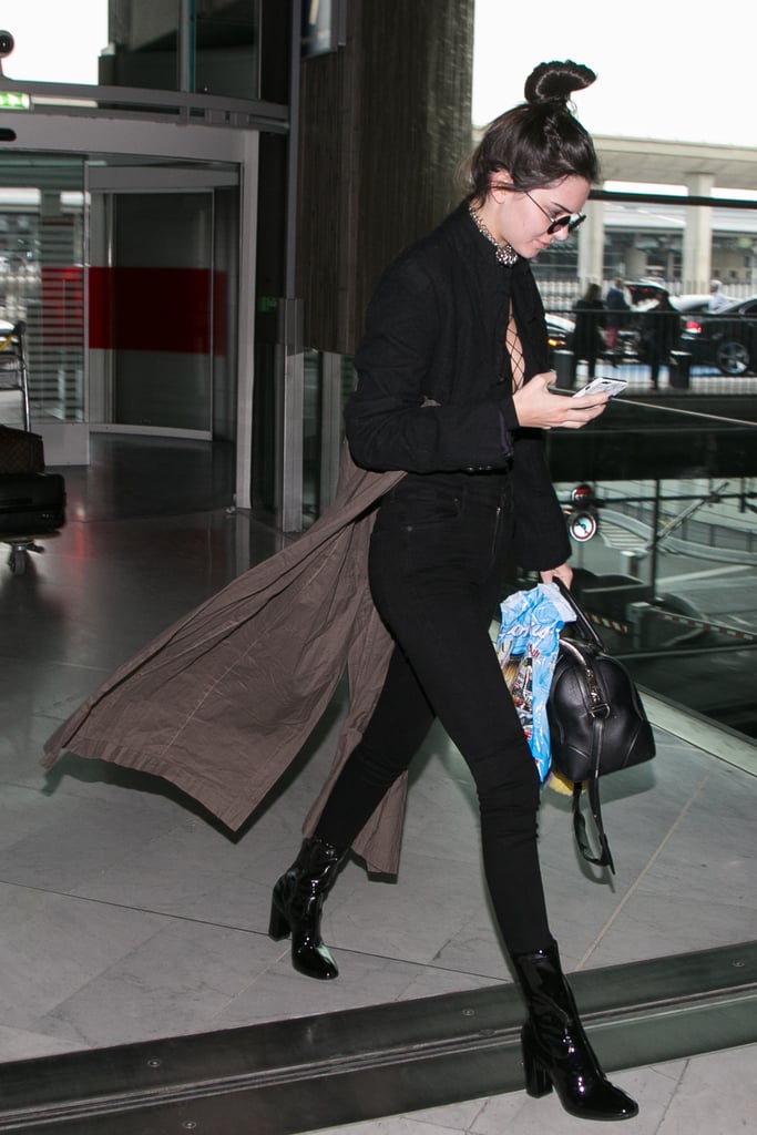 Kendall trekked home in a two-toned Comme des Garcons duster, taking the sexy route with an Alexander Wang lace-up bodysuit, tight-fitting Citizen of Humanity jeans, Kenneth Cole booties, and eye-catching accessories, including a Zimmermann choker, Givenchy bag, and Oliver Peoples retro frames.