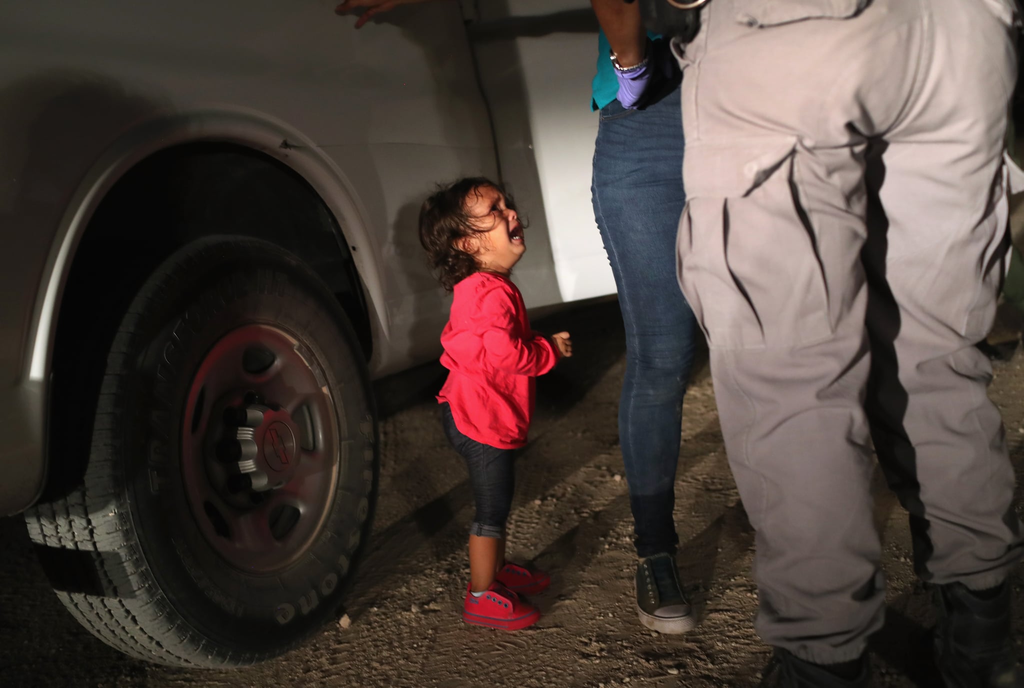 MCALLEN, TX - JUNE 12:  A two-year-old Honduran asylum seeker cries as her mother is searched and detained near the U.S.-Mexico border on June 12, 2018 in McAllen, Texas. The asylum seekers had rafted across the Rio Grande from Mexico and were detained by U.S. Border Patrol agents before being sent to a processing center for possible separation. Customs and Border Protection (CBP) is executing the Trump administration's 