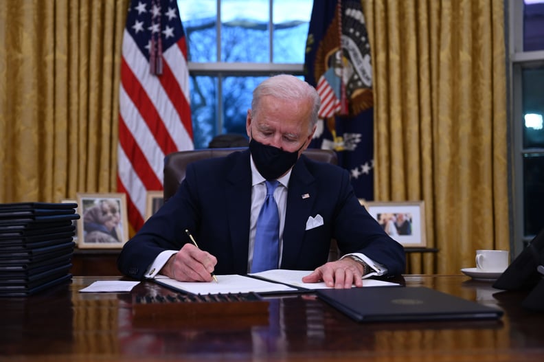 TOPSHOT - US President Joe Biden sits in the Oval Office as he signs a series of orders at the White House in Washington, DC, after being sworn in at the US Capitol on January 20, 2021. - US President Joe Biden signed a raft of executive orders to launch 
