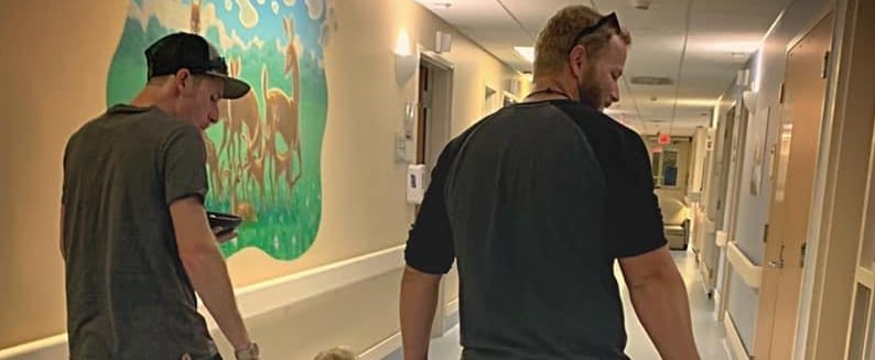 Photo of Dad and Stepdad Holding Boy's Hands at Hospital