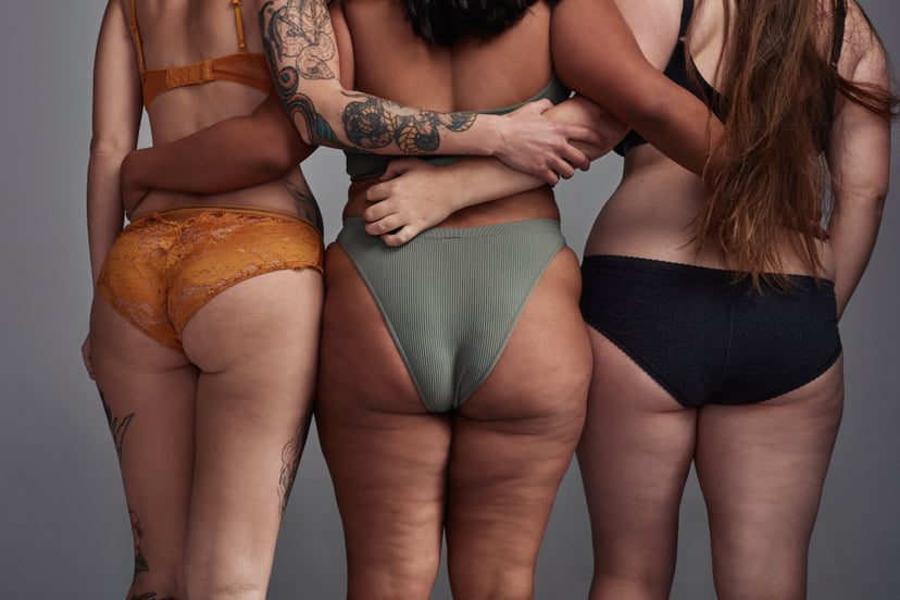 Shot of three young women posing in their underwear against a grey background