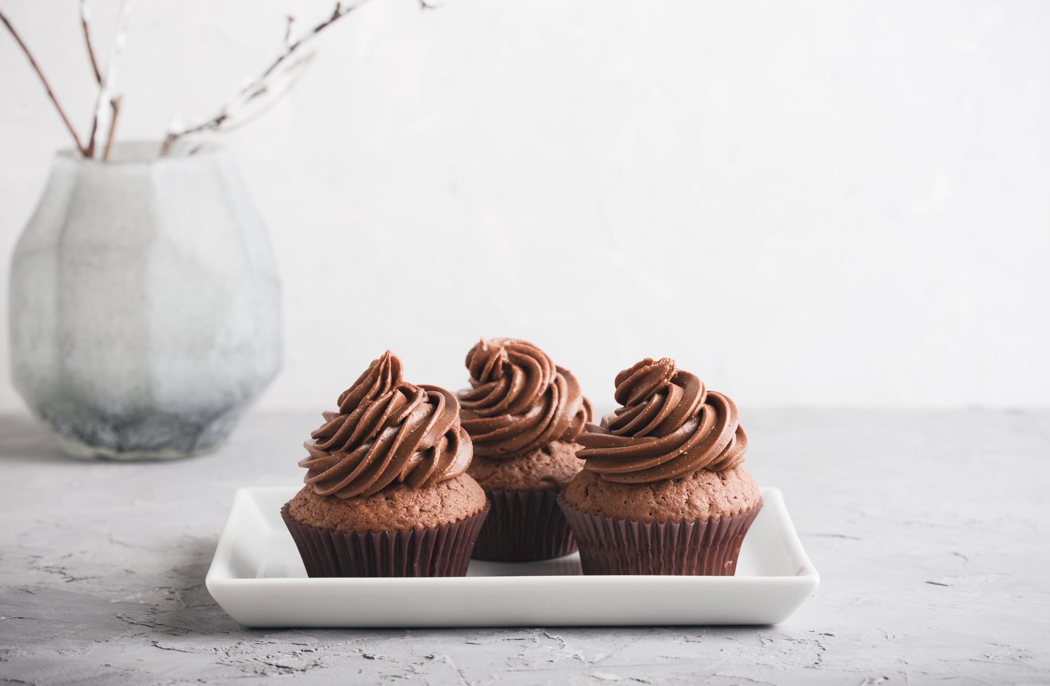 Delicious chocolate caramel cupcakes on grey background