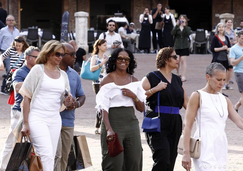 Michelle Obama Wore a White Off-the-Shoulder Top by Club Monaco, Olive Pants, and a Gold Elizabeth and James Cuff