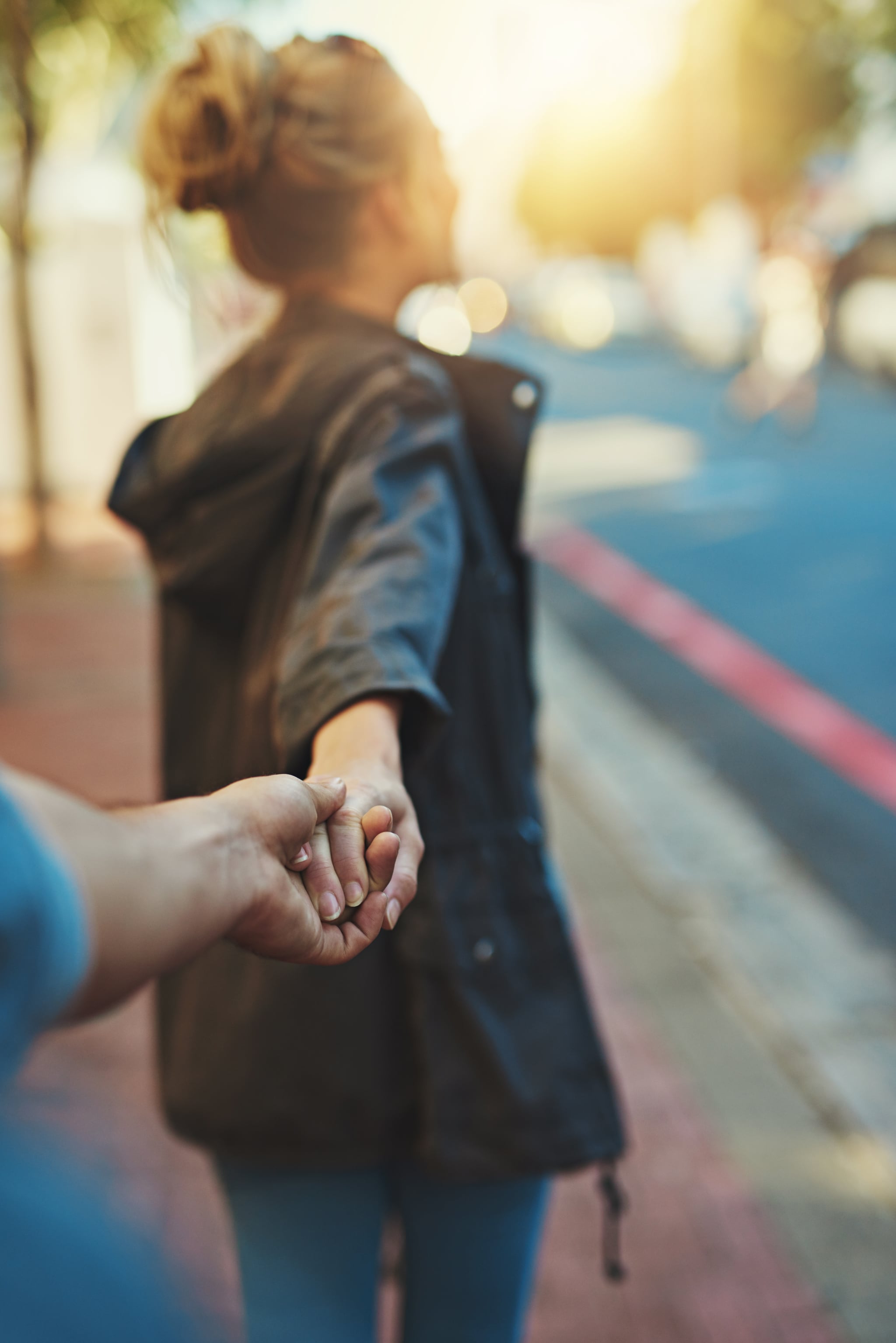 Shot of a young woman pulling on her boyfriend's hand