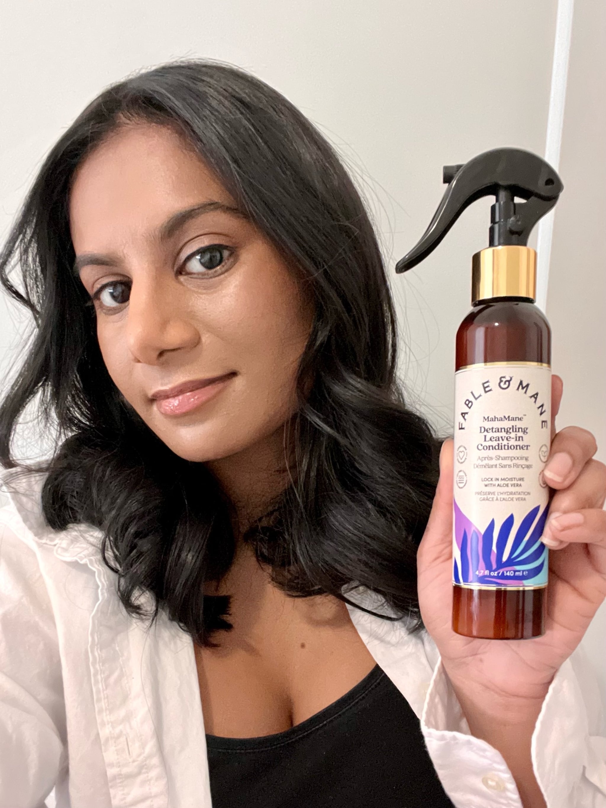 woman holding the Fable and Mane Mahamane Detangling Leave-In Conditioner.