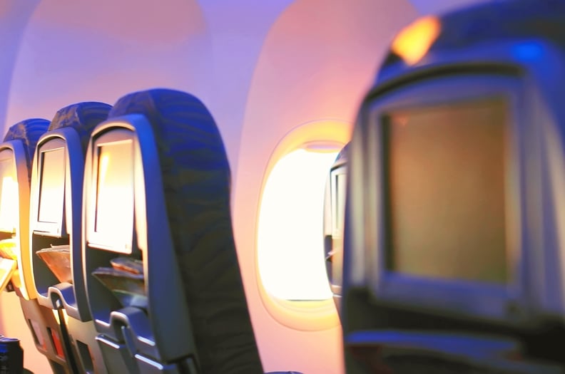 The back of a row of airplane seats in soft lighting