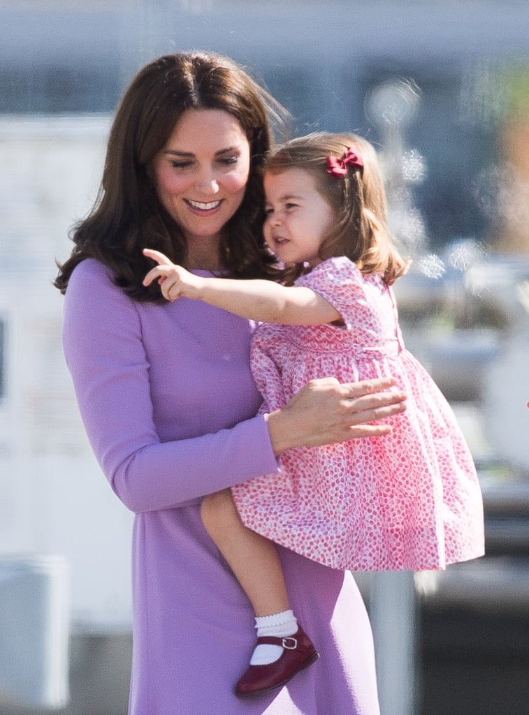 During a visit to Germany in July 2017, Charlotte wore a red polka-dot dress with burgundy shoes and a matching hair clip.