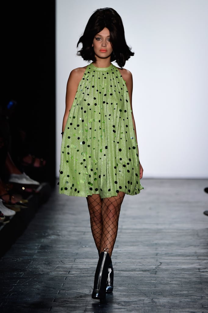 Bella walked the Jeremy Scott runway in a high-neck sequin-embellished babydoll dress that was complete with fishnet tights and zipper-clad ankle booties.