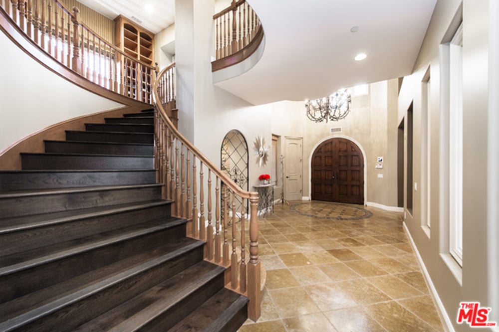 A winding staircase sets a welcoming tone in the home's entryway.
