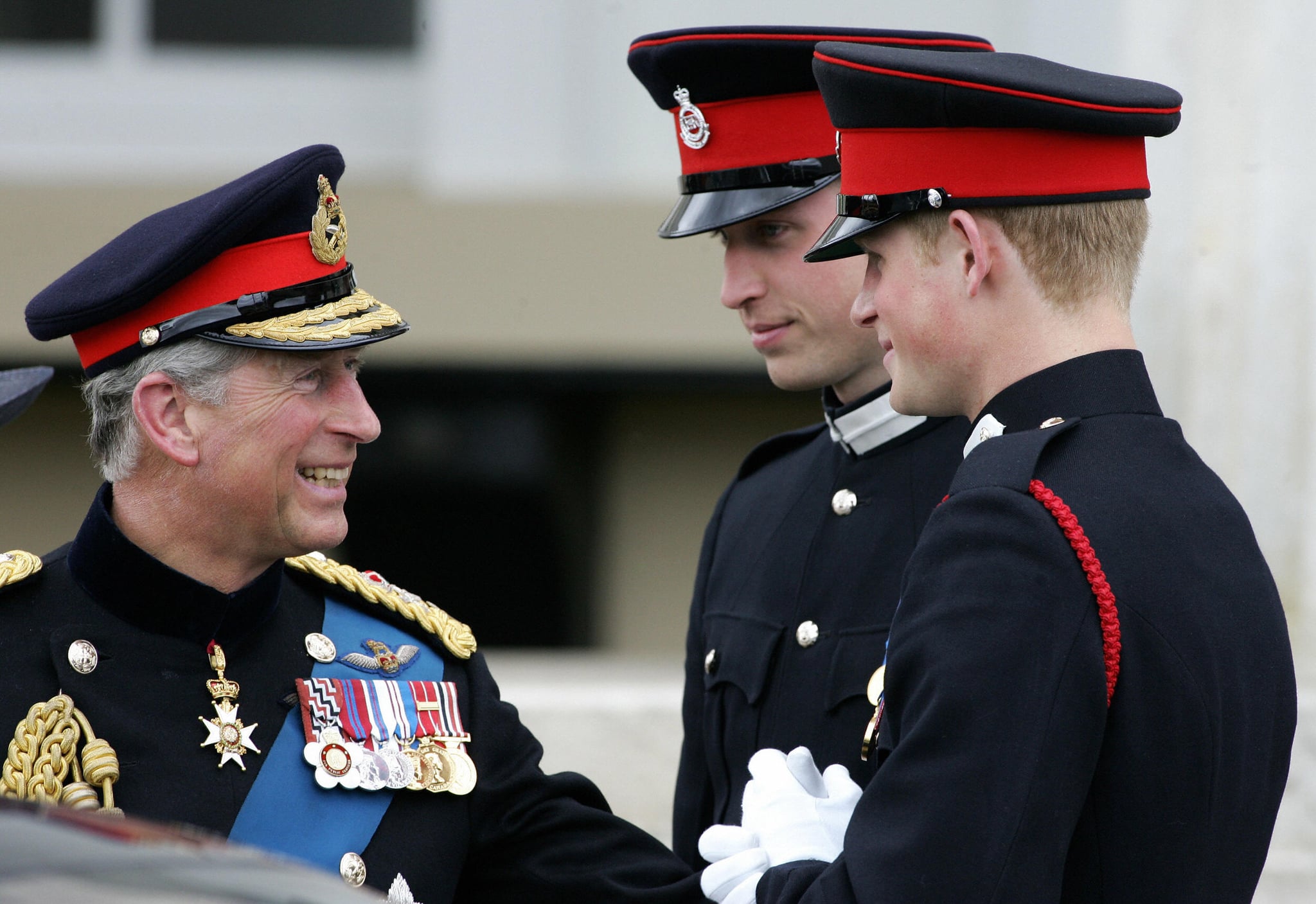 Sandhurst, UNITED KINGDOM:  Britain's Prince Charles (L) speaks with his two sons Prince's William (C) and Harry (R) after attending the Sovereign's Parade at the Royal Military Academy in Sandhurst, southern England, April 12, 2006. Officer Cadet H Wales as Prince Harry is known, will train to become a troop commander, in charge of 11 enlisted men and four light tanks -- a job that could soon see him on front-line duty in Iraq or Afghanistan. His grandmother Queen Elizabeth II, who turns 80 on April 21, and father Prince Charles both turned out for the passing-out ceremony where Harry and 218 other officer cadets in crisp blue uniforms, each carrying thin silver swords, received their commissions after 44 weeks of gruelling training. AFP PHOTO/CARL DE SOUZA  (Photo credit should read CARL DE SOUZA/AFP via Getty Images)