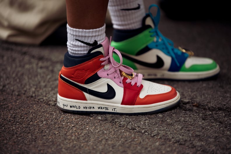 COPENHAGEN, DENMARK - AUGUST 09: A guest wearing two different color Nike Air  sneakers, one red and other green and Nike socks posing outside Gestuz show during Copenhagen Fashion Week Spring/Summer 2023  on August 09, 2022 in Copenhagen, Denmark. (Photo