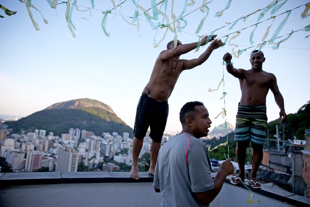 People in Rio de Janeiro put up streamers over their patio to prepare for the World Cup.