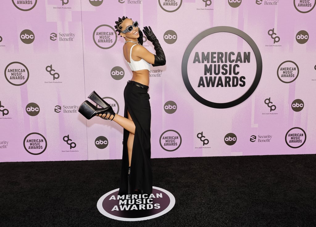 Tinashe带她风格到新的高度在2022年全美音乐盛典。这位歌手出席了颁奖礼在洛杉矶11月20日穿马克·雅可布从头到脚,包括一个特别的一双高跟鞋multistrap平台。从品牌的2022年秋季收集成衣,Tinashe看看由出现白色的胸衣和低层,拖地裙细皮带和高缝。Tinashe点缀广场太阳镜印有品牌以及银链项链,匹配的耳环,和上述ankle-testing平台。Tinashe还穿着歌剧手套,使许多去年出现在红地毯,包括著名的联欢晚会。Tinashe经常boundary-pusher在红地毯上。本周早些时候,她参加了GQ男人的聚会在11月17日穿着一个灰色Ottolinger西装衬衫下面。前几天,Tinashe庆祝Thierry Mugler布鲁克林博物馆的展览开幕式筹备11月15日穿着Mugler分离和超大的耳环。看到Tinashe大胆的红地毯的照片往前看,然后检查出其他恒星穿着美国音乐奖。相关:屡获殊荣的美丽看起来Tonight'美国音乐奖
