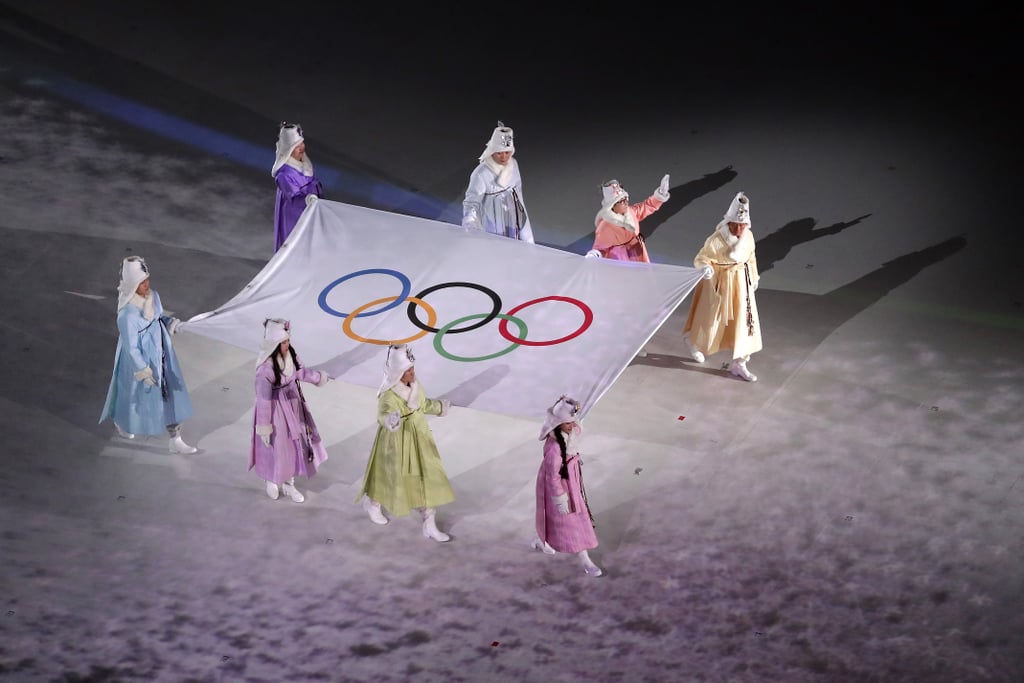 The official Olympic flag is carried into the stadium.