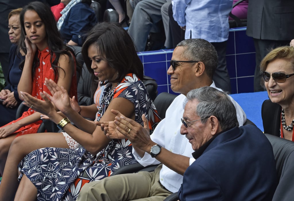 Michelle wearing a bright floral Tory Burch dress at a baseball game in Havana.
