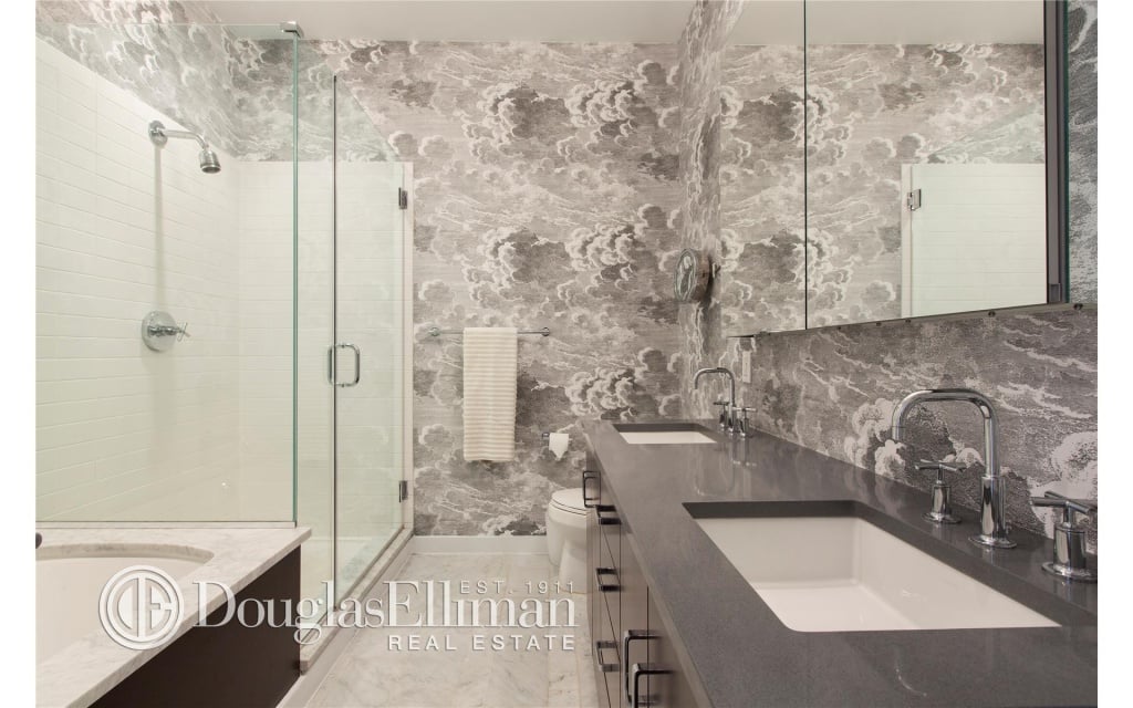 The luxe master bath features double sinks, a large tub, and a separate shower stall.
