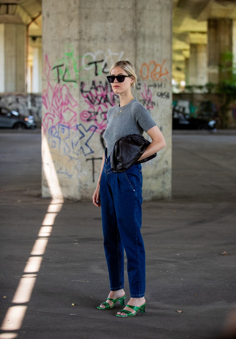 Wear a Pair of Dark Denim '80s-Style Trousers With Metallic Sandals and a Gray Tee