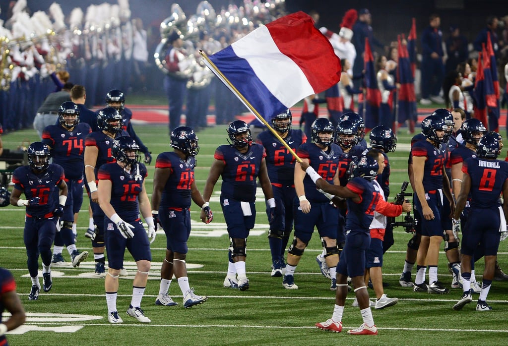 A football player proudly waved a French flag before a game between Utah and Arizona in Tuscon, AZ.