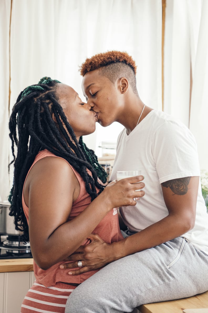 Lesbian Couple Kissing In Kitchen