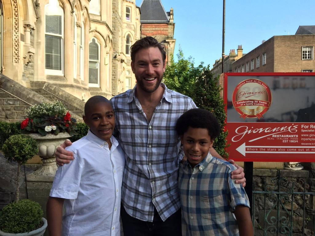 The handsome star took a moment to pose with two fans.