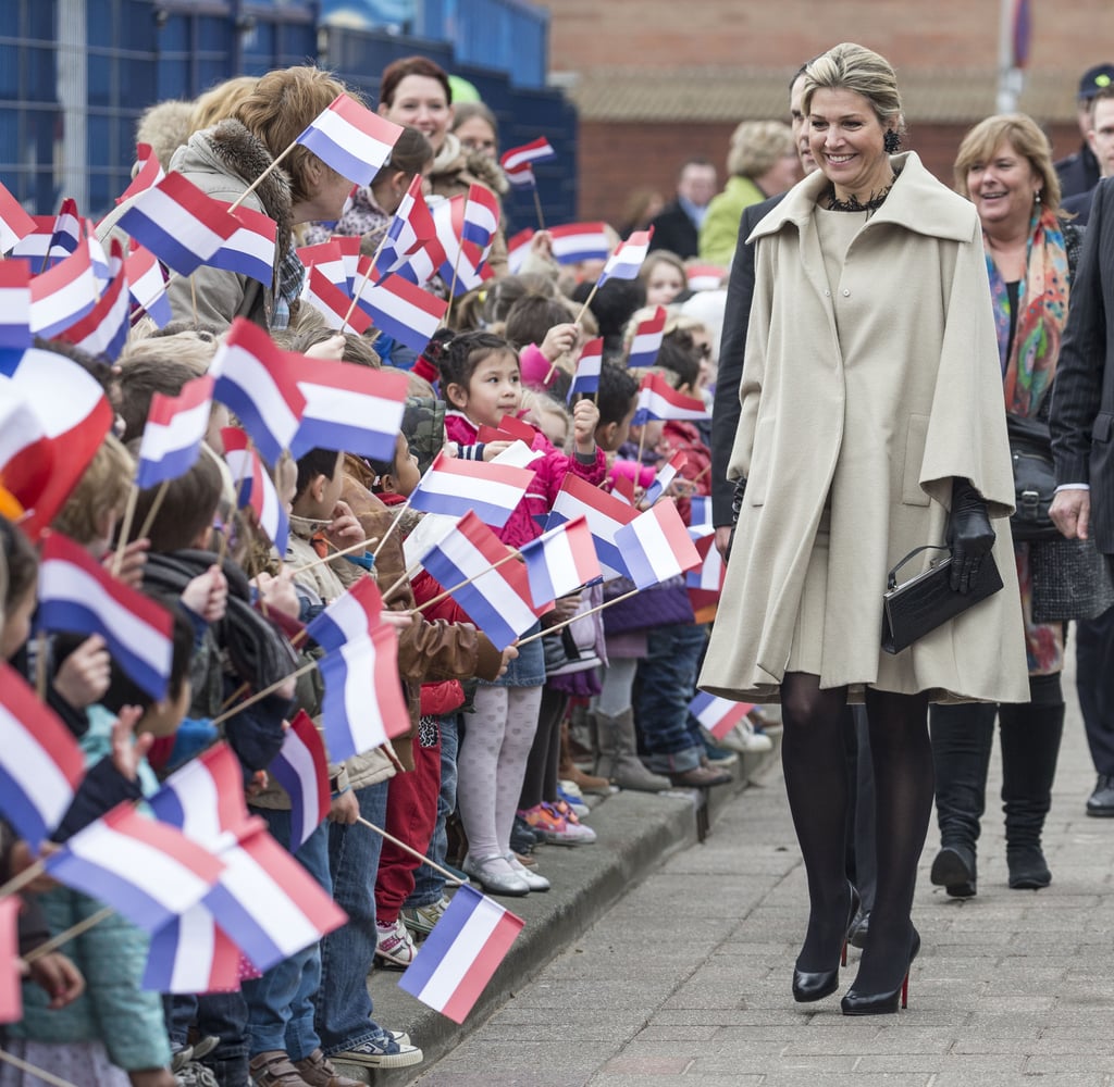 Queen Maxima of the Netherlands wearing a taupe cape coat.