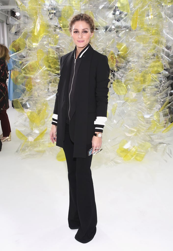 At Michael Kors, Olivia went sleek in all black, pairing flares with a varsity jacket and layering a black blazer on top.