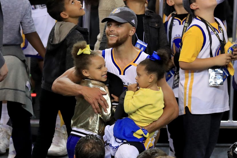 OAKLAND, CA - JUNE 12:  Stephen Curry #30 of the Golden State Warriors celebrates holding his daughters Riley and Ryan after defeating the Cleveland Cavaliers 129-120 in Game 5 to win the 2017 NBA Finals at ORACLE Arena on June 12, 2017 in Oakland, Califo