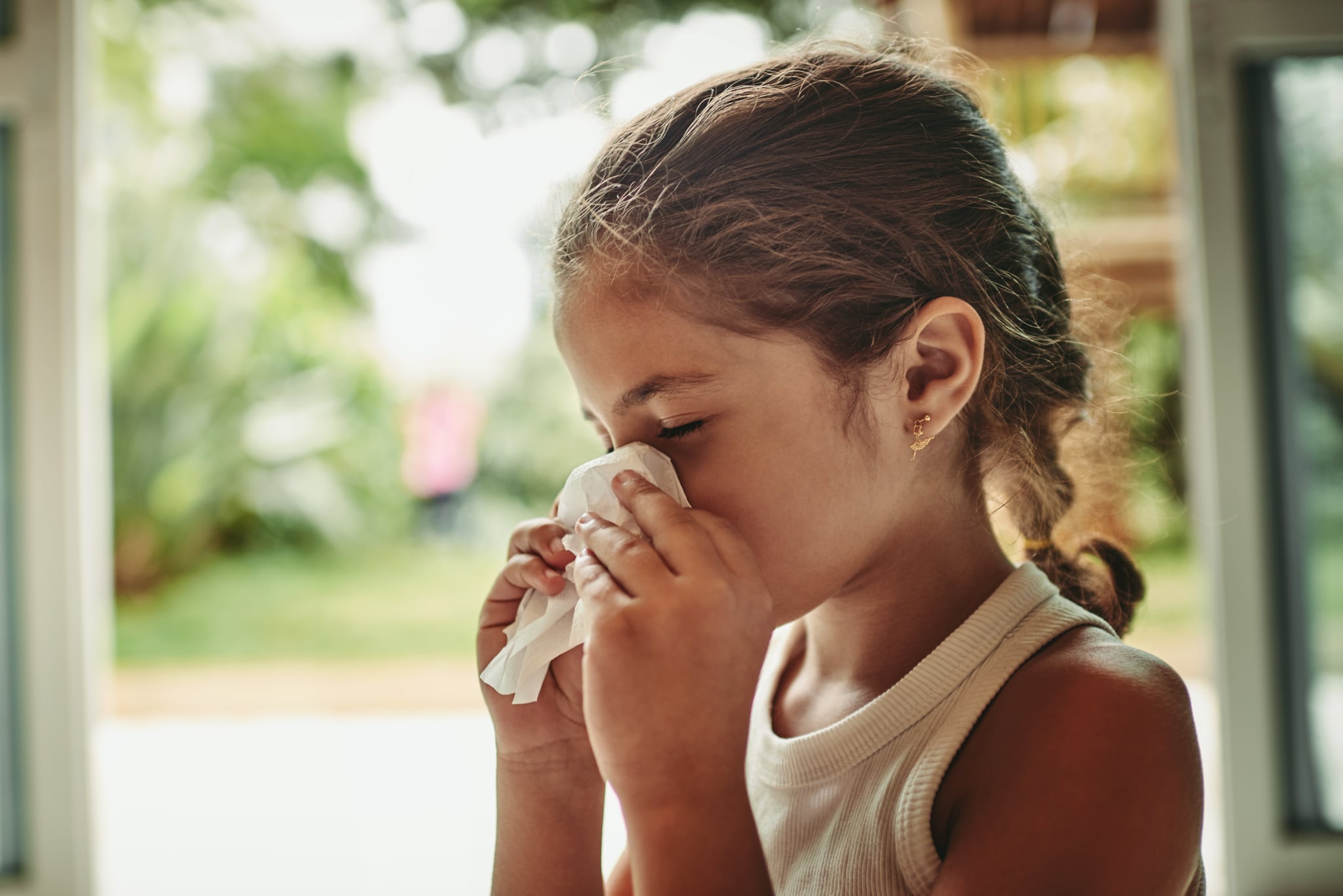 Shot of a young girl blowing her nose