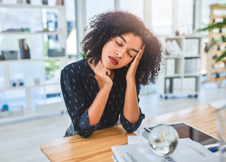 Cropped shot of an attractive young businesswoman sitting alone in her office and suffering from a headache