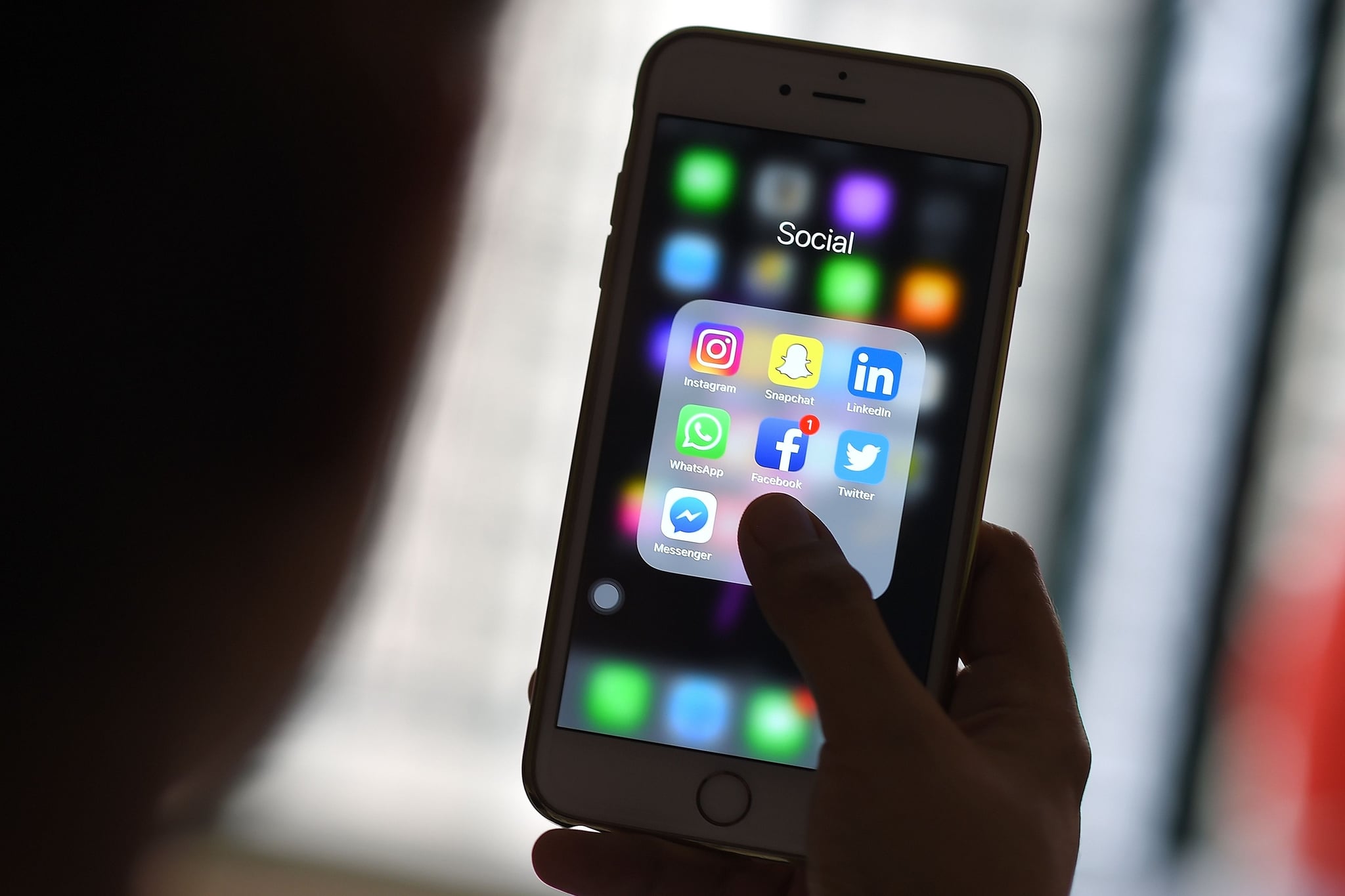 This photo illustration taken on March 22, 2018 shows a woman looking at Social Networking applications Facebook, Instagram, Snapchat, Whatsapp, Twitter, Messenger and Linkedin on a smartphone in Kuala Lumpur. / AFP PHOTO / Manan VATSYAYANA        (Photo credit should read MANAN VATSYAYANA/AFP/Getty Images)