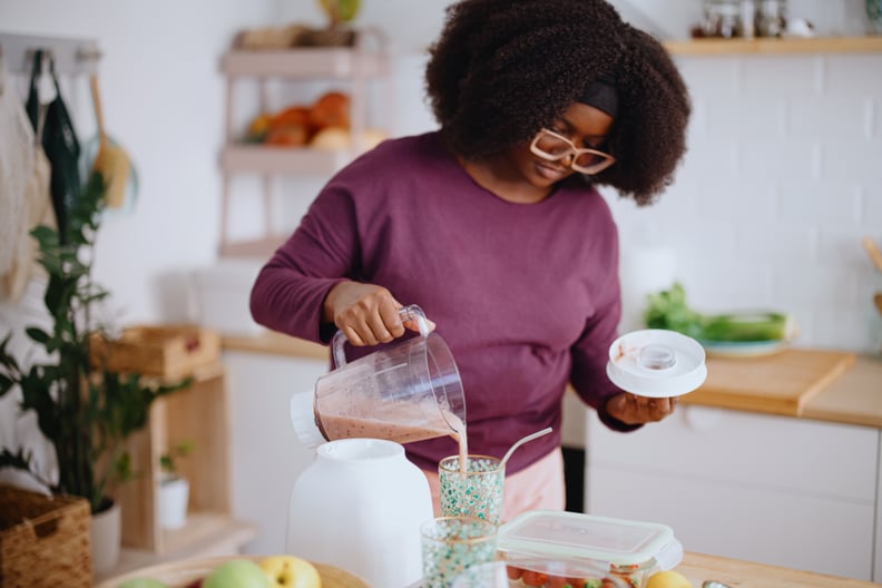 Young black woman preparing healthy protein smoothie in her kitchen