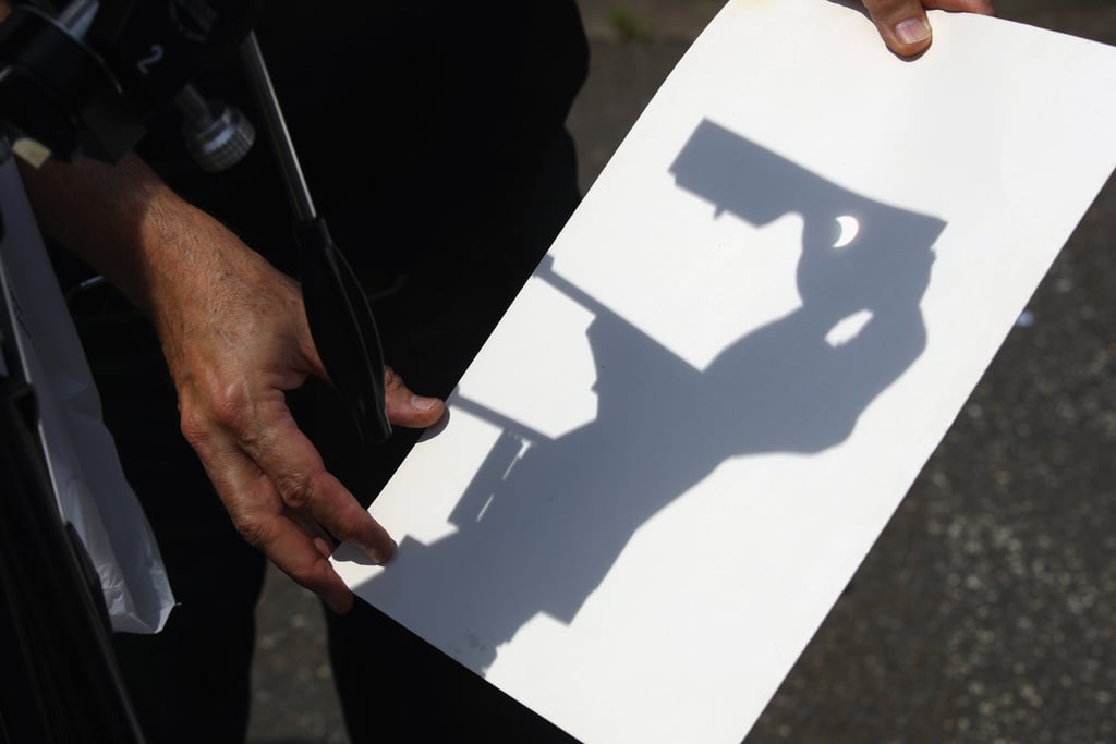 With a spotter scope, a person views the partial eclipse at the Cradle of Aviation Museum in Garden City, NY.