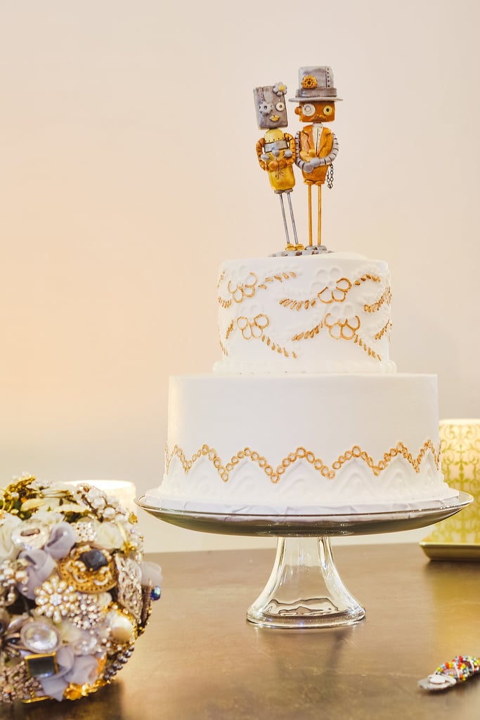 This classic tiered cake looks like it was hand-embroidered with a floral and leaf pattern, and we love that the topper adds a fun, quirky touch.
