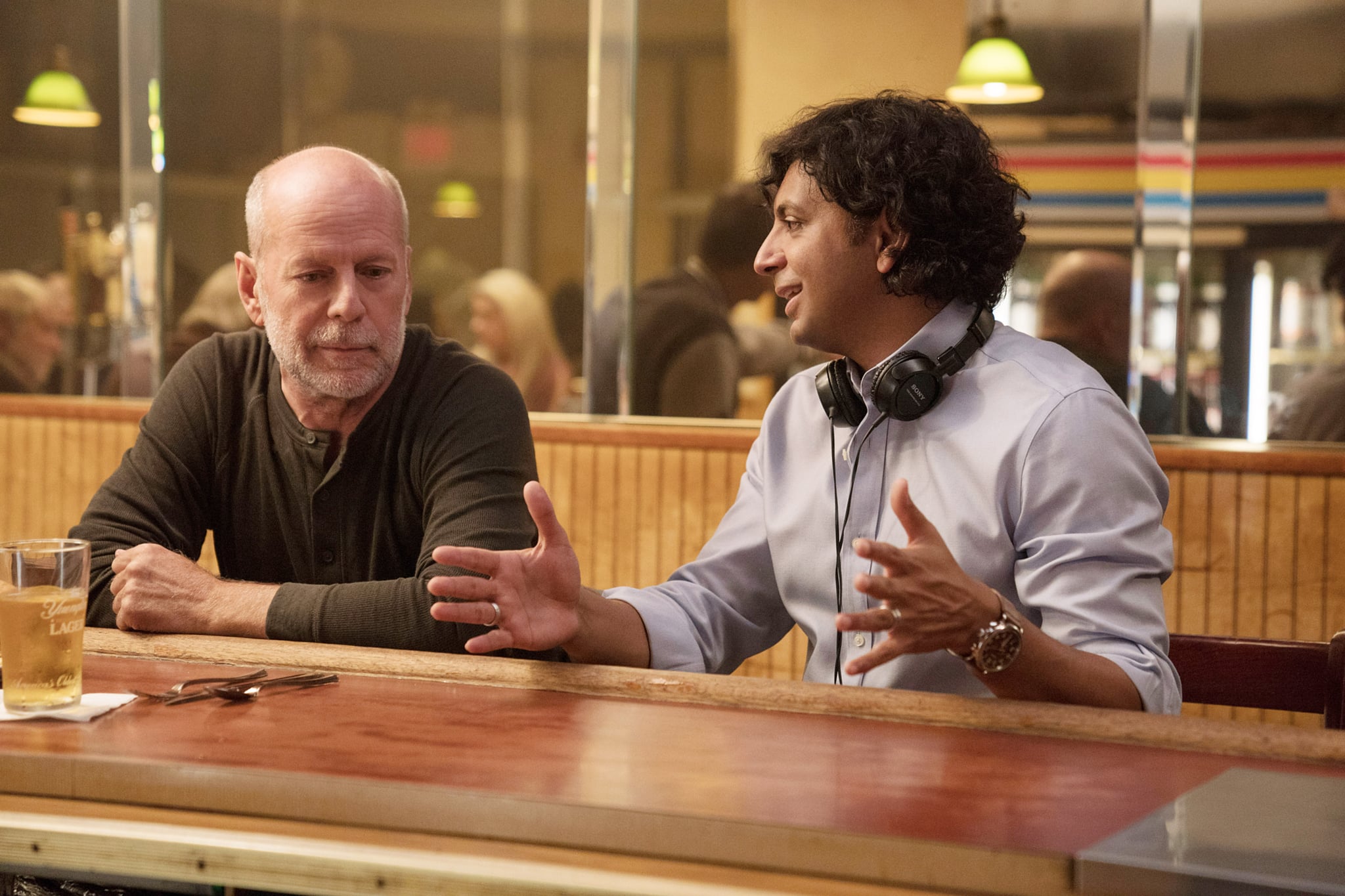 GLASS, from left: Bruce Willis, director M. Night Shyamalan, on set, 2019. ph: Jessica Kourkounis /  Universal /Courtesy Everett Collection