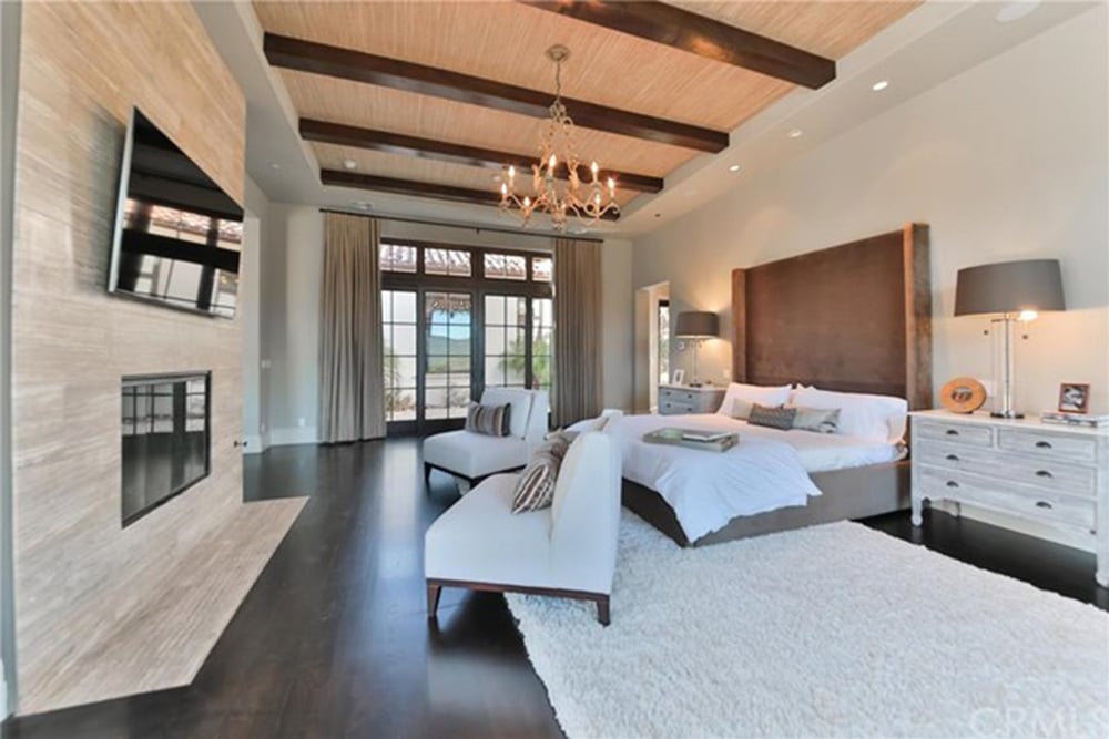 Wooden beams add texture and style to the bedroom ceiling.